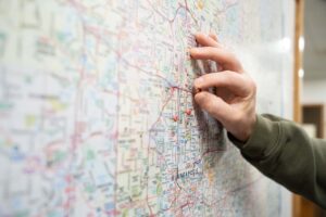 Hand placing pushpin on map