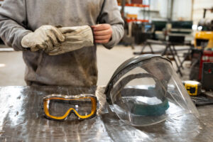 Shop worker with protective gear on table